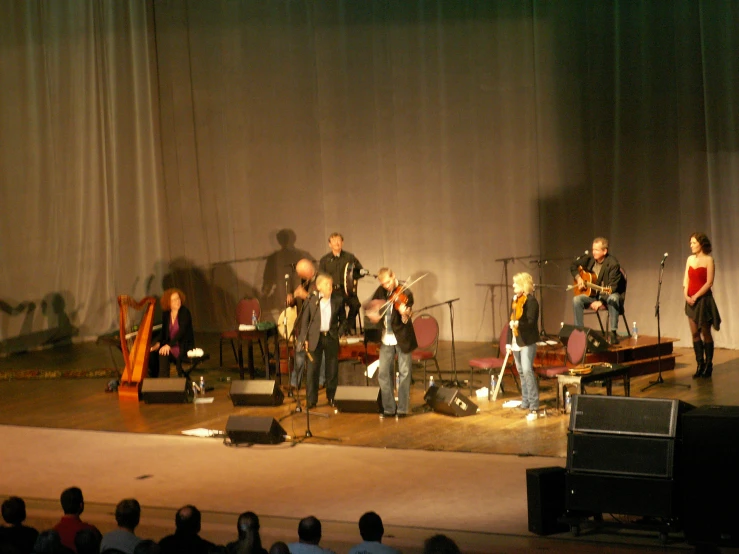 a large group of people on stage with instruments