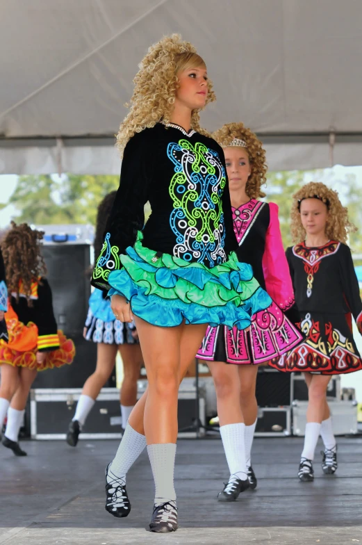 a runway shows several models in colorful outfits