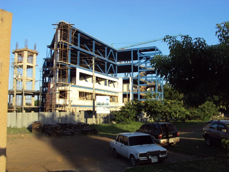 a white car in front of an unfinished building