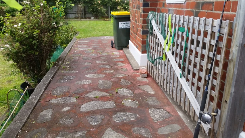 bricked pathway leading to fenced in yard next to building