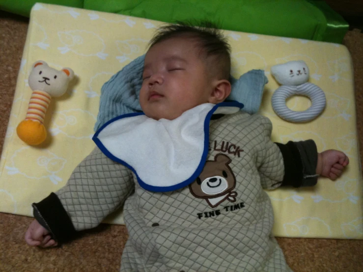 a baby laying on his side next to toys