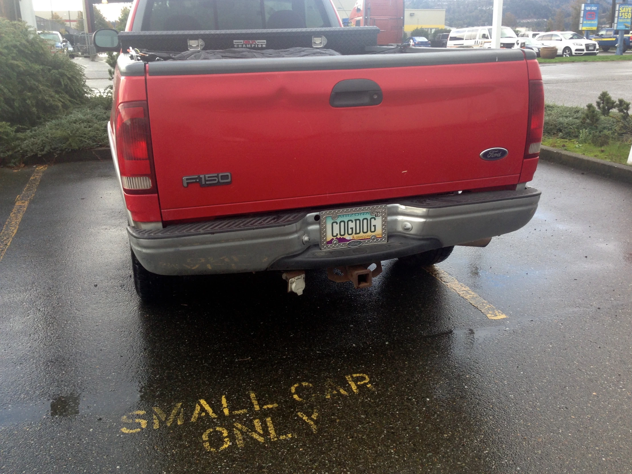 there is a red pick up truck parked on the side of the street