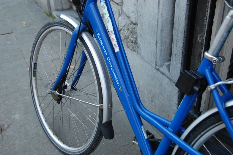 a blue bicycle is parked against a wall