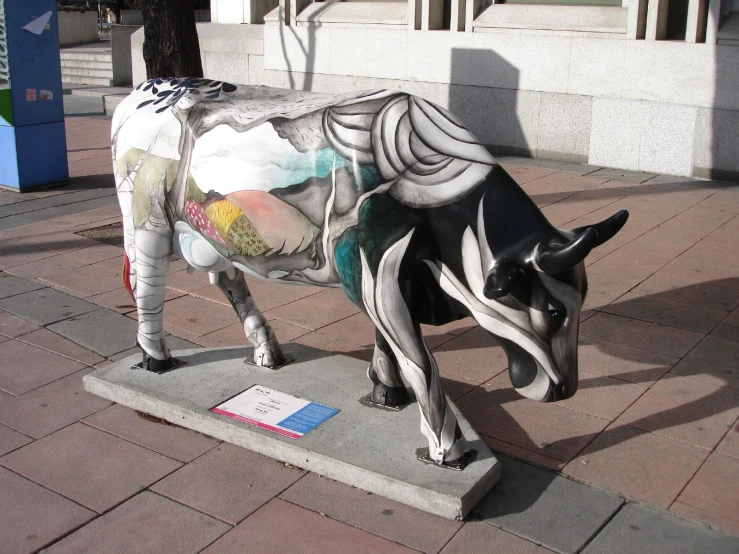 a statue of a cow on a sidewalk