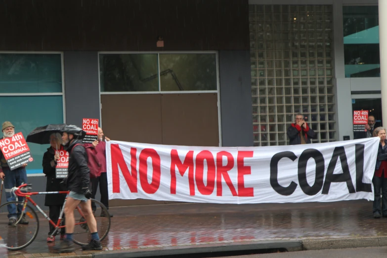 a group of people with signs that read no more coal