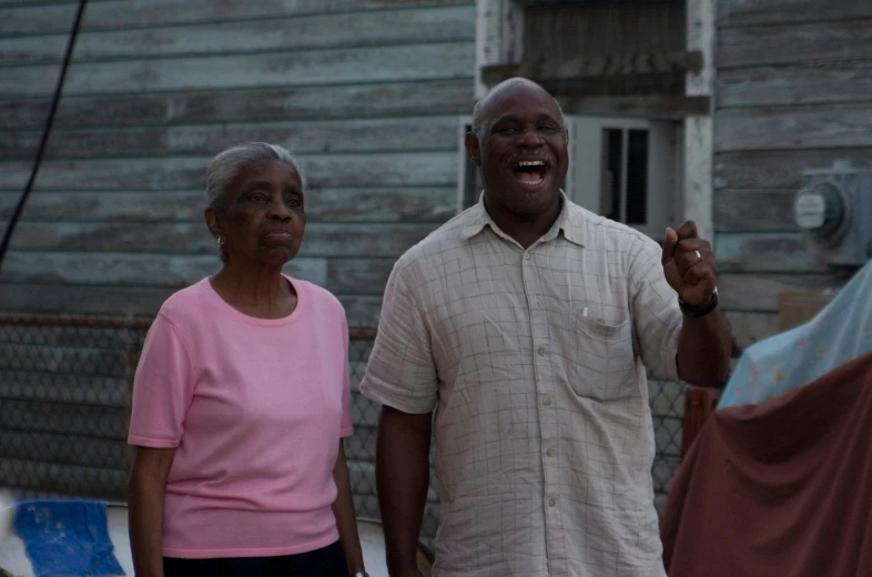 an older black man standing next to a woman outside