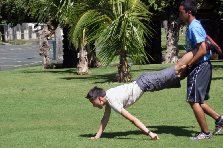 two people playing with a frisbee while one man watches