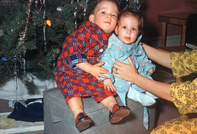 a woman holding a baby who is sitting on a small table