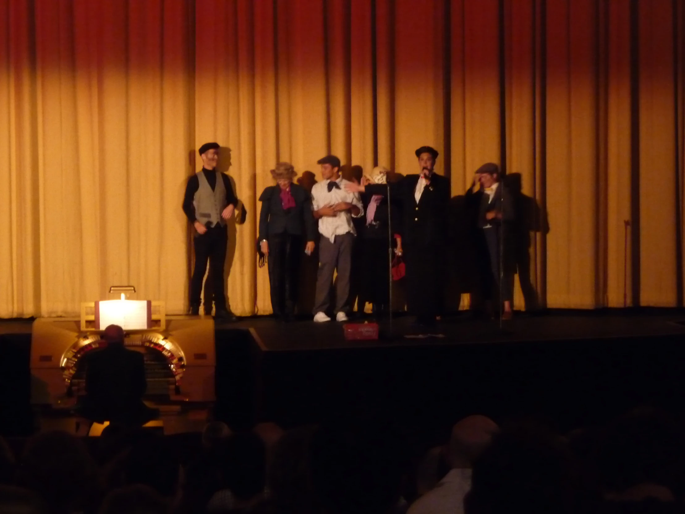 group of people standing on a stage and one standing up