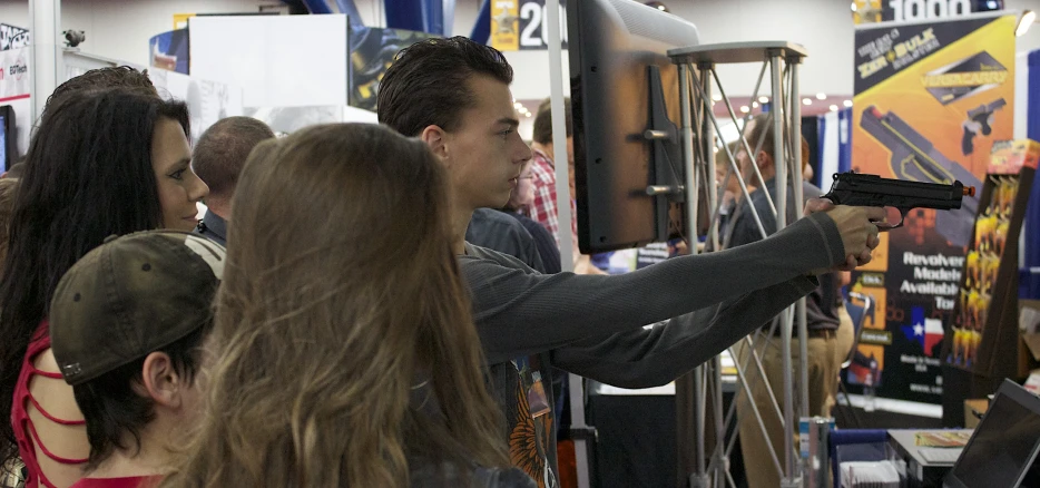 two people aiming at a display in a building