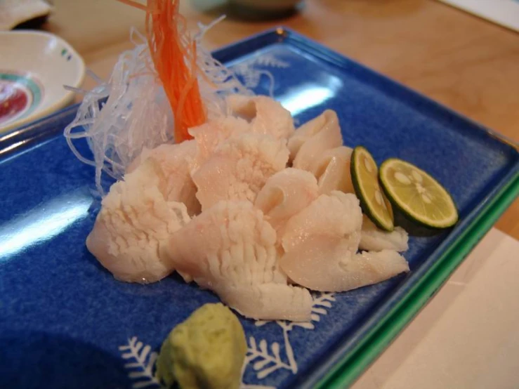 a food dish made with raw fish sits on a plate