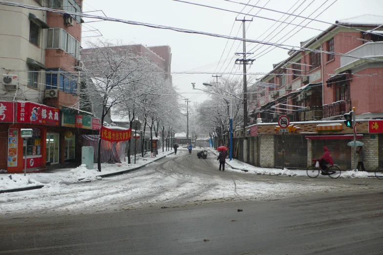 a snowy street filled with people and buildings