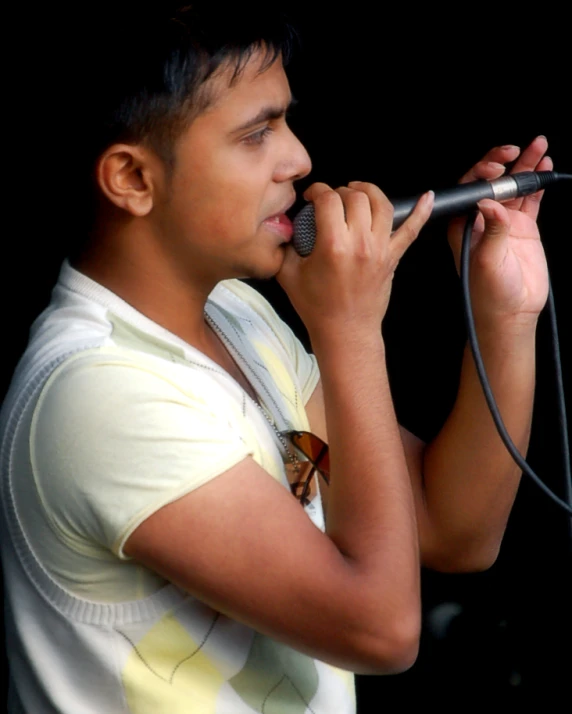 a young man holding a microphone up to his mouth