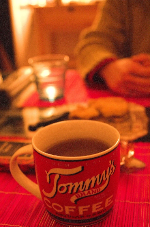 a red and white coffee cup sits on a table