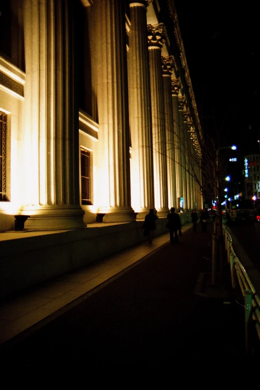 people sitting under an arch lit up in the dark