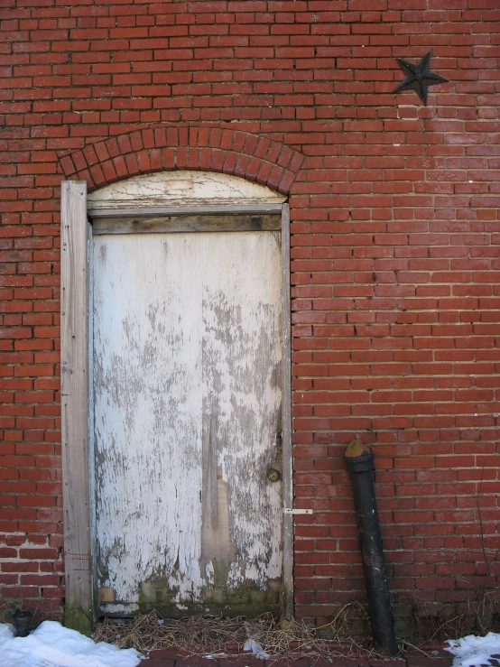 old white door in between two brick wall