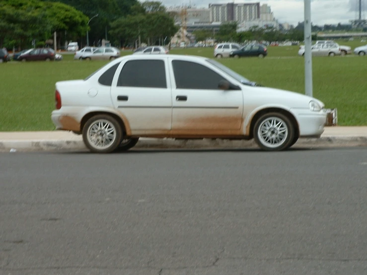 the white car is parked on the side of the road