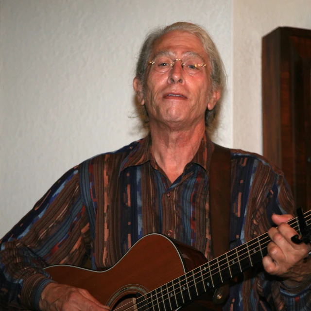 a man playing an acoustic guitar in the living room