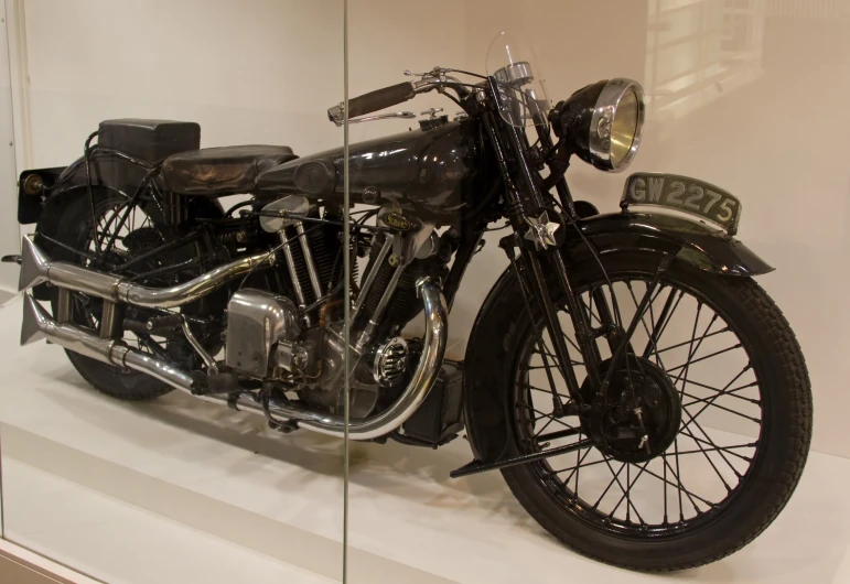 a motorcycle sits in front of a glass case