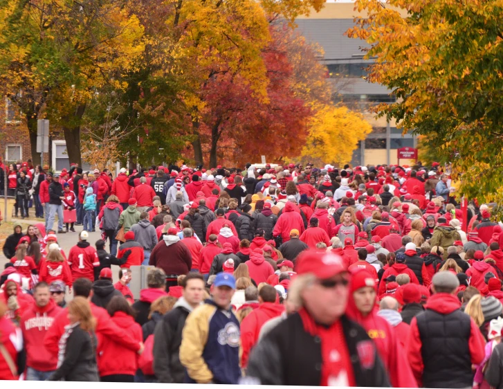 a crowd of people standing in a street next to trees