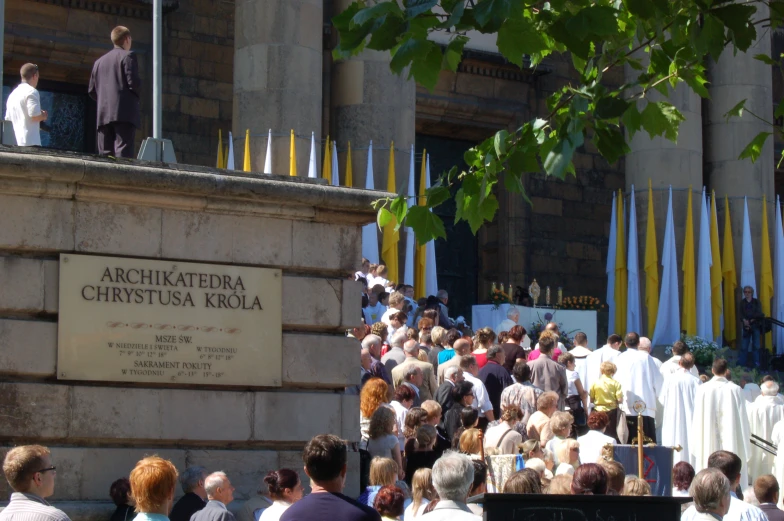 a large crowd is gathering at an old church to see the priests