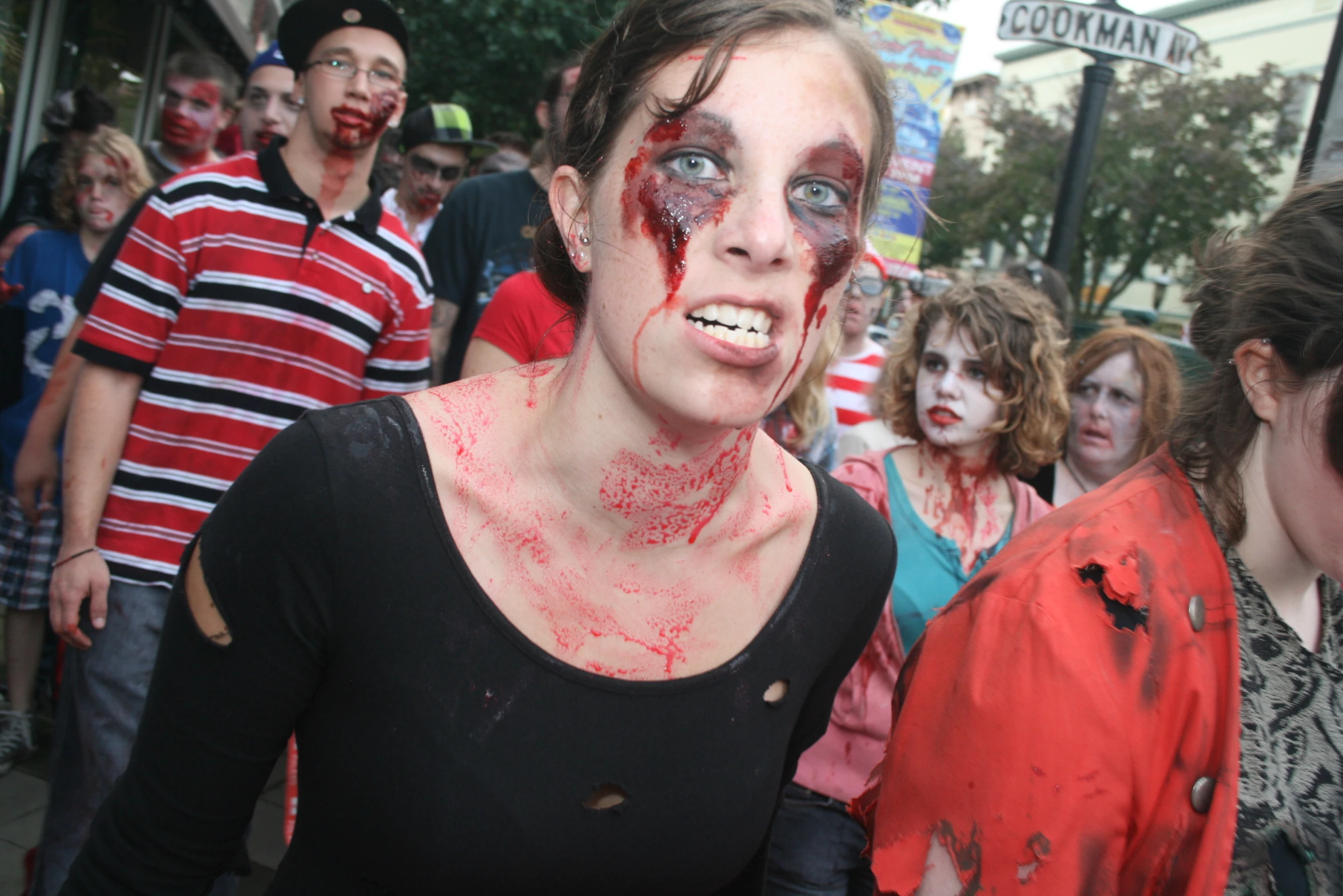 a woman with red face paint and a bunch of people standing