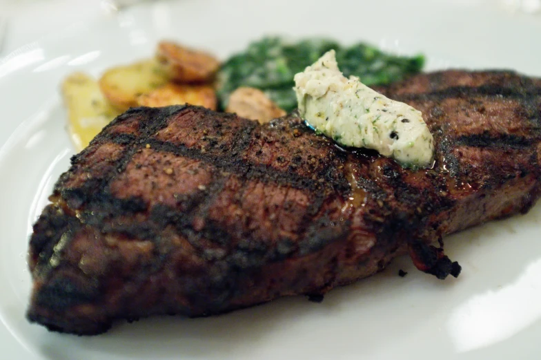 a steak, potatoes and broccoli on a white plate