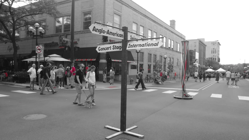 many people are walking in a cross walk in the street