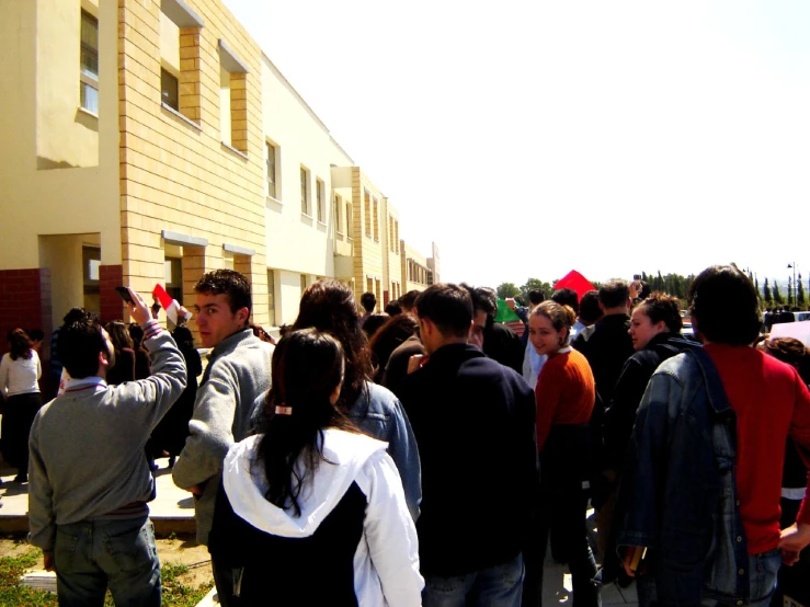 many people standing outside and watching others walk by