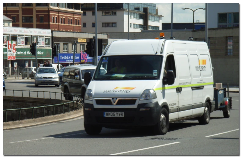 white van with orange writing on the side is driving down a road in traffic