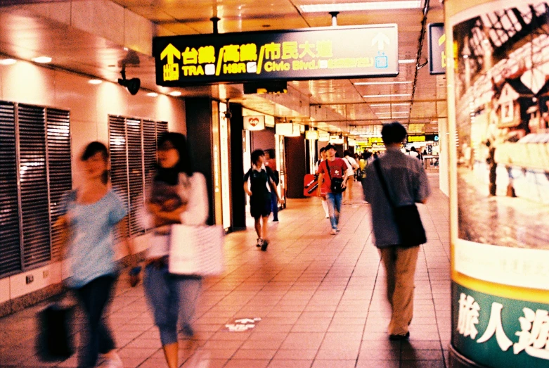 the crowd of people are walking around a subway