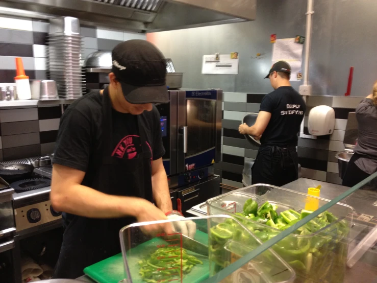 two people in a kitchen preparing food on trays