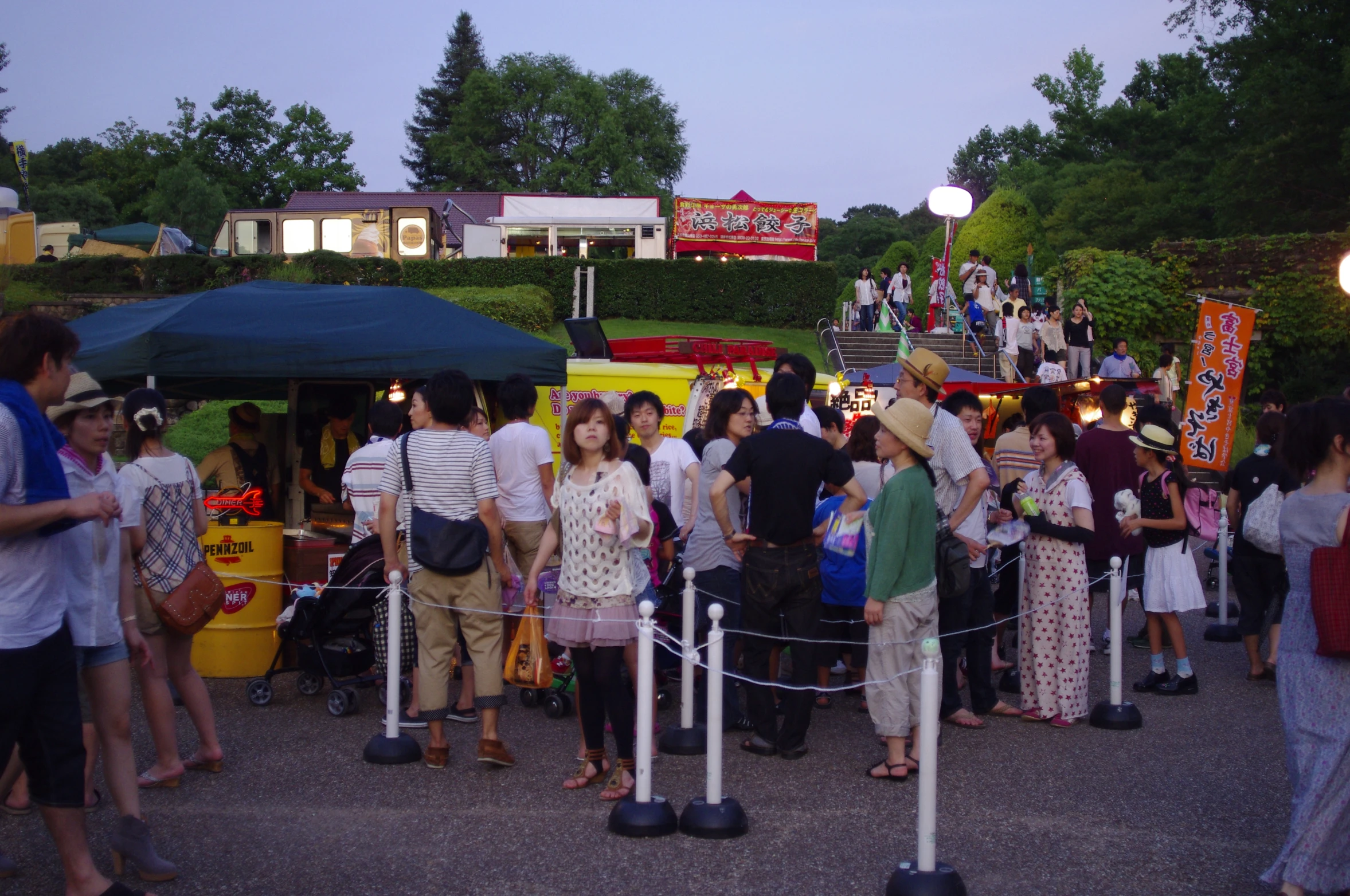 many people stand around booths at a fair