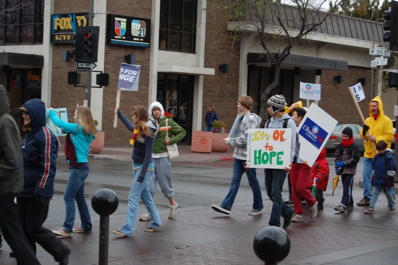 group of people holding signs during a protest with flags and hats