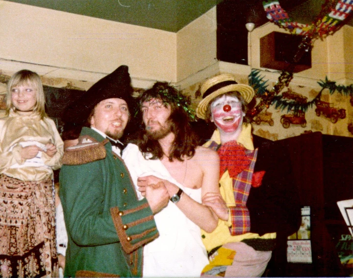 a group of clowns pose for a po in a small kitchen