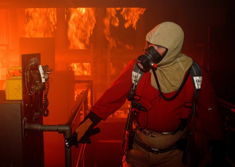 a man wearing a helmet standing in front of some machines