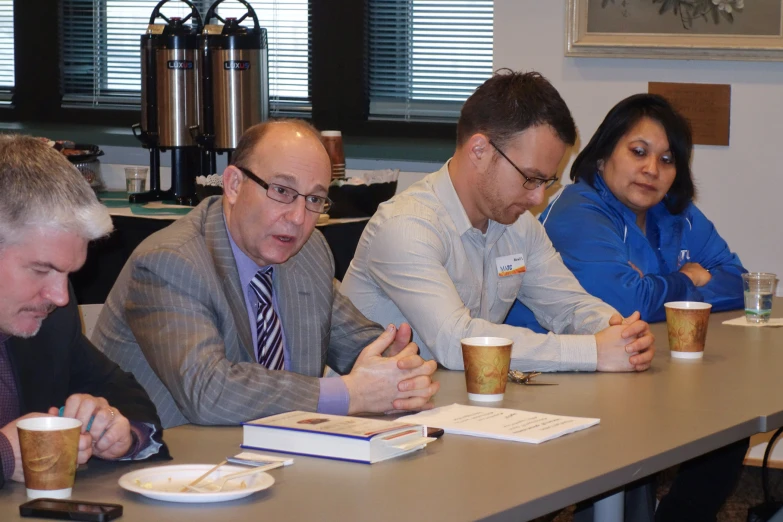 a group of men sitting at a table with beverages