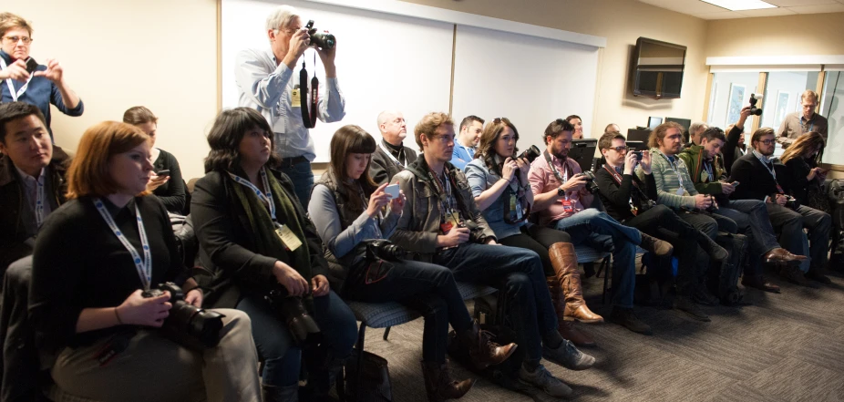 a large crowd watching a man speak into a microphone