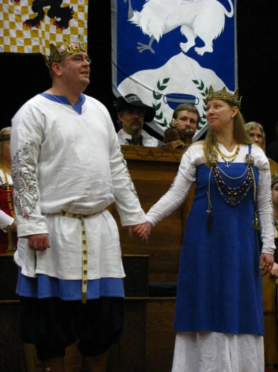 a man and woman wearing roman clothing shaking hands