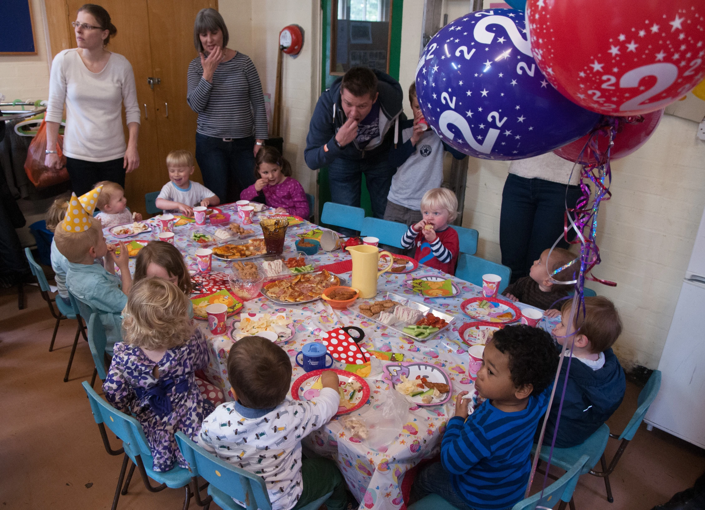 many adults and children are at a table