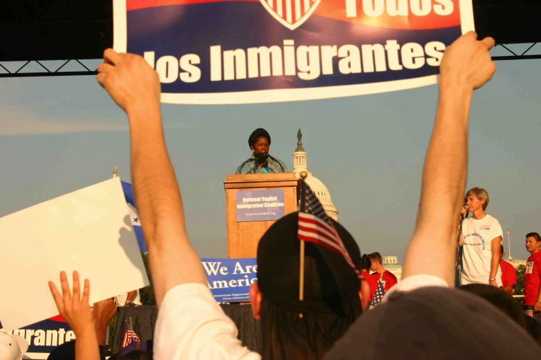 a man standing at a podium holding a flag