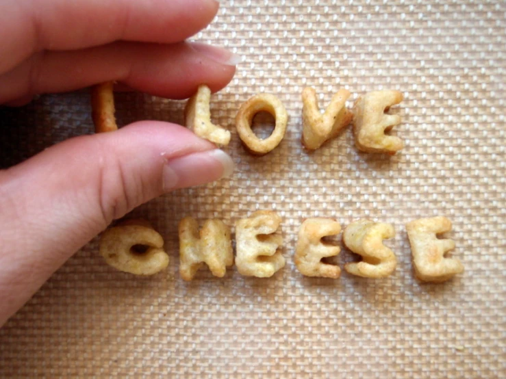 someone holds the word love cheese spelled by two ers