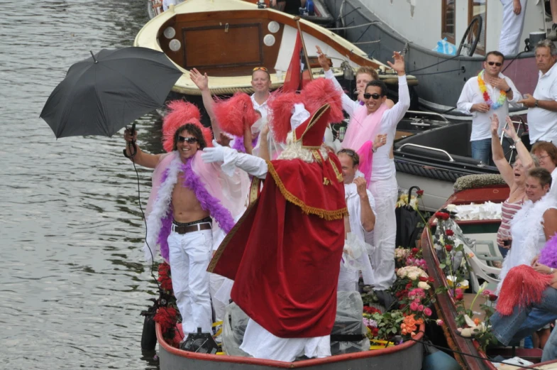 people in costume riding on top of a boat