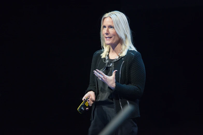 a woman speaking to a large audience at an event