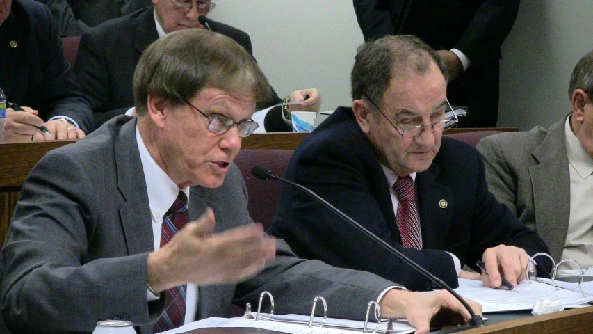 two men sitting next to each other in front of microphones