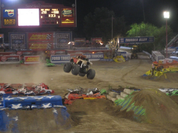 several four wheelers riding in a field near a stadium