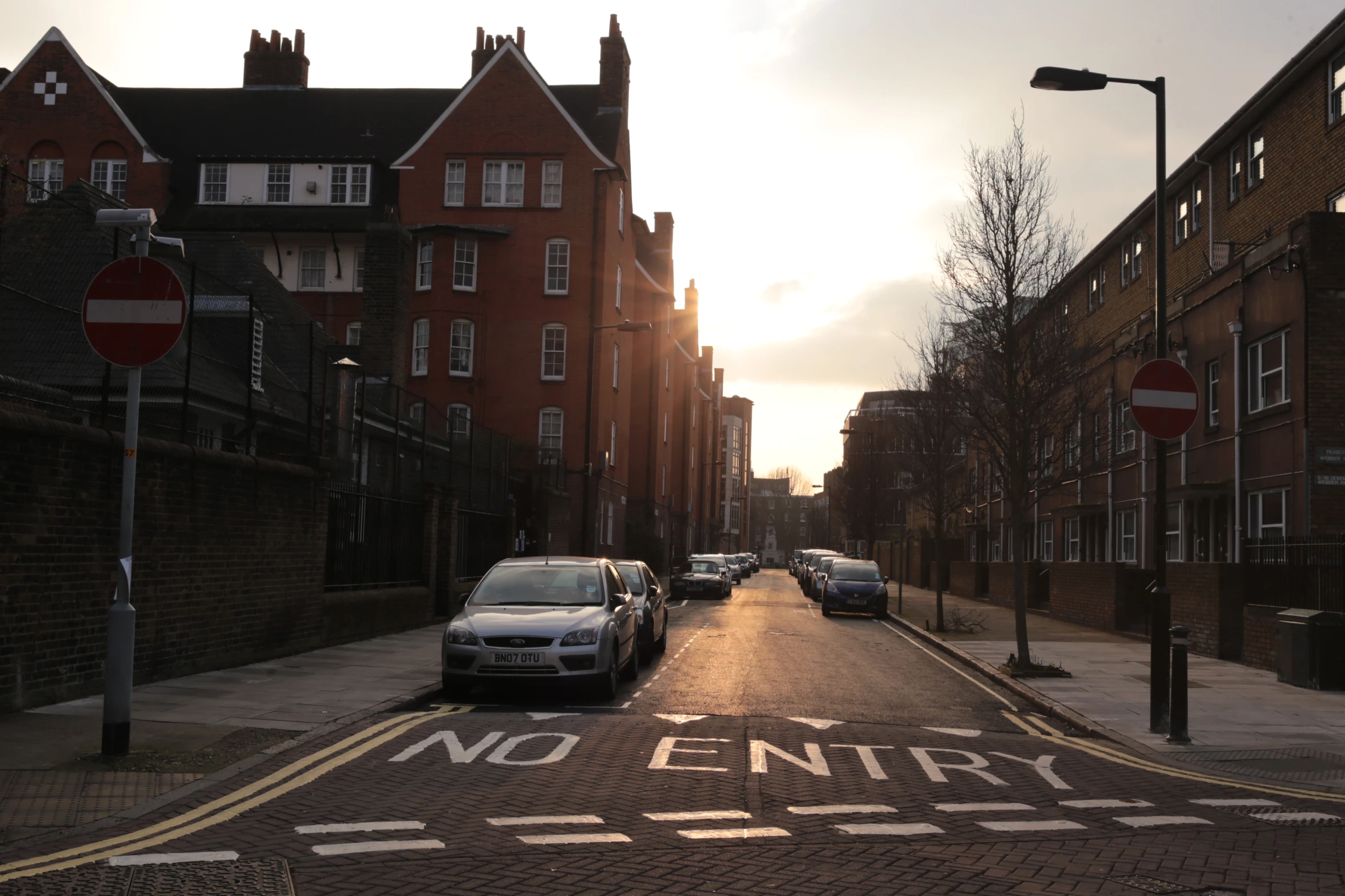 several cars parked on the side of an empty street