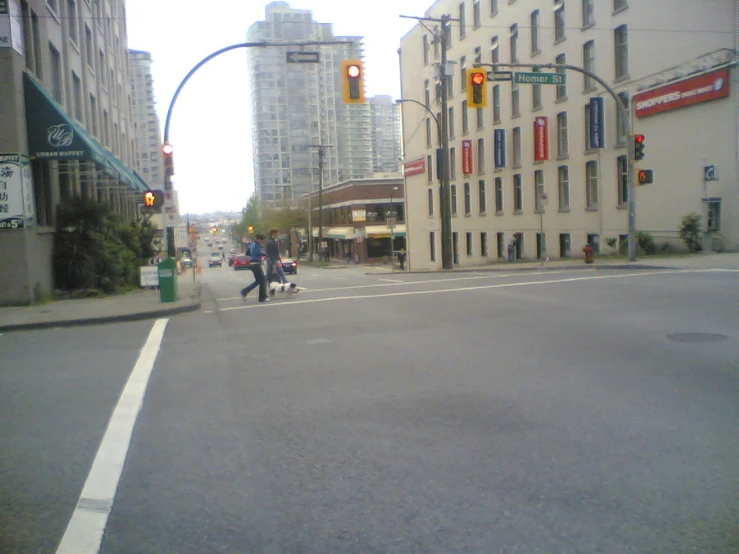 a couple cross the street at an intersection