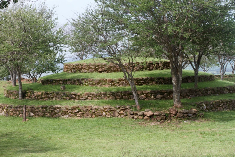 several different stones sitting in the grass near trees