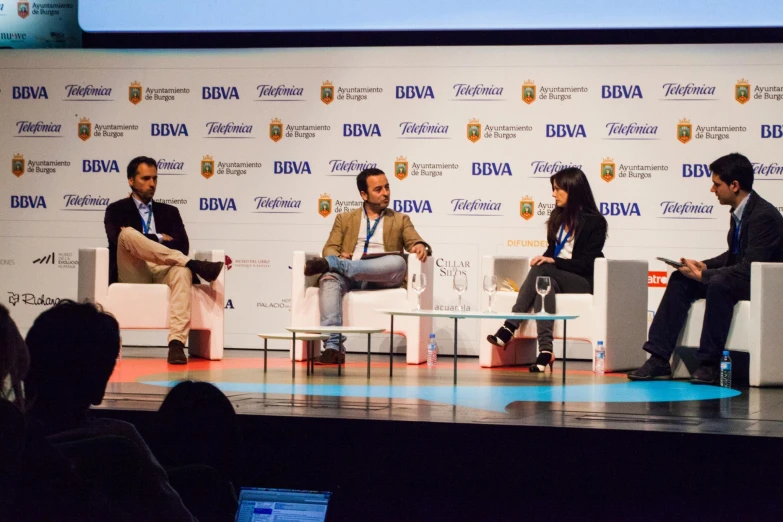 four people sitting on chairs during a panel discussion